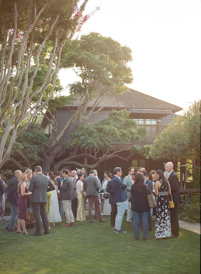 Guests gathered beneath the courtyard tree at golden hour
